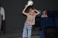 Dziewczynka z publiczności, która bawi się podczas przedstawienia w MOK w pierwszym planie, za nią drugie dziecko.