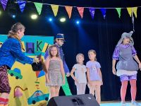 Aktorzy na scenie oraz publiczność w trakcie trwania przedstawienia.