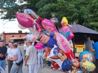 Ludzie przy straganach między innymi z balonami na Odpuście na Świętego Rocha w Lutkówce.