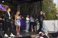 Koncert zespołu, muzycy i przedstawiciele publiczności na scenie.