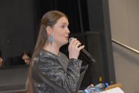 Agata Klimczak- Kołakowska instruktorka podczas rozpoczęcia i powitania przed przedstawieniem. W dłoni trzyma mikrofon,...