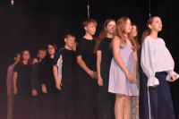 Aktorzy ustawieni w kolejkę podczas śpiewania piosenki na scenie MOK.