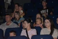 Publiczność na scenie sali kinowo- teatralnej podczas oglądania przedstawienia.