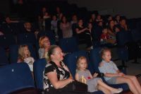 Publiczność na scenie sali kinowo- teatralnej podczas oglądania przedstawienia.