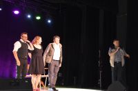 Kierownik MOK na scenie witający Kabaret Rewers oraz trójka aktorów.