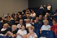 Zdjęcie publiczności podczas występu, pełna widownia.