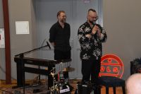 Dwóch muzyków przed występem, z instrumentami muzycznymi.