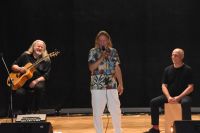 Trzech muzyków, w tym Marek Piekarczyk podczas koncertu na scenie MOK.