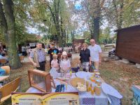 Organizatorzy i uczestnicy Dnia Pszczoły przy stoisku animacyjnym.