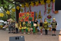 Dzieci na scenie w przebraniach pszczół podczas zabawy animacyjnej.