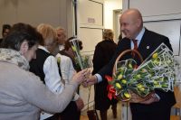 Burmistrz Mszczonowa Łukasz Koperski podczas wręczania kwiatów z okazji Dnia Kobiet.